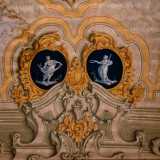 Attorno alla scena otto ovali mostrano le raffigurazioni delle muse con in mano i loro attributi iconografici: maschere, strumenti musicali e pergamene